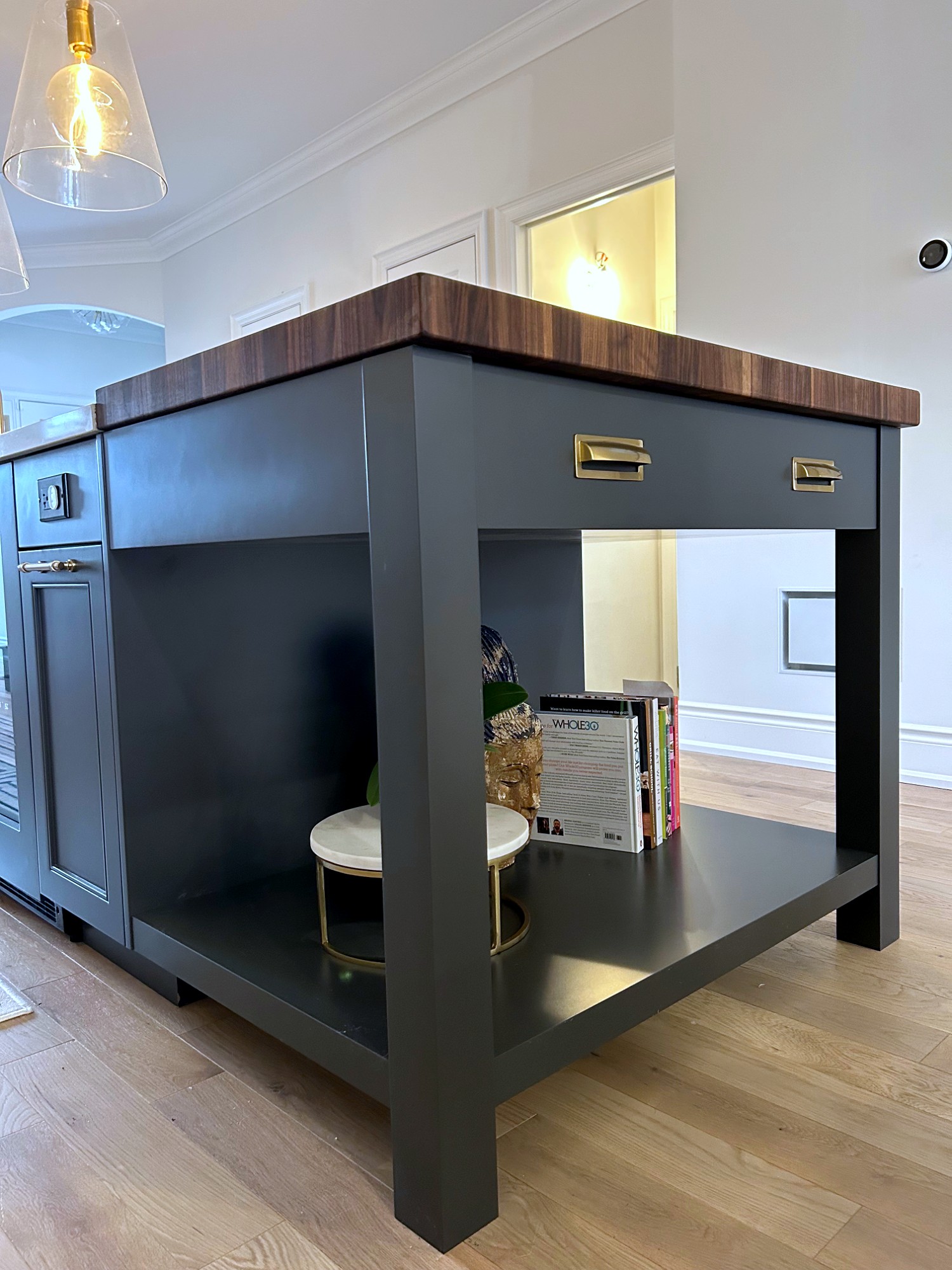 Two-tone kitchen with black cabinetry and walnut island top