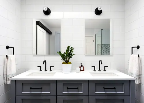 Charcoal shaker double vanity with matte black bar pulls and a white quartz counter with twin undermount sinks and black faucets, set against oversized white subway tile with twin mirrors